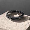 Pulsera de hombre de piel trenzada con cordón negro y cierre magnético de acero.