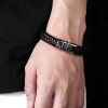 Herenarmband van gevlochten leer met stalen sluiting en spinnenmotief