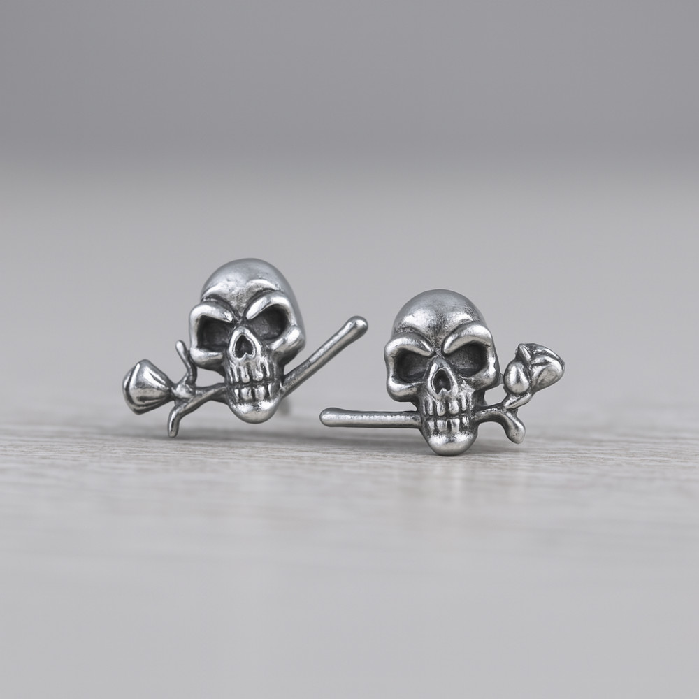 Zilveren heren oorbellen met roze doodskop studs