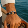 Bracciale da uomo in pelle nera, cordini in acciaio, chiusura con grillo marino