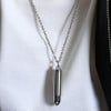Colgante personalizado para hombre en acero con acabado pulido y diseño de cruz en forma de bala.